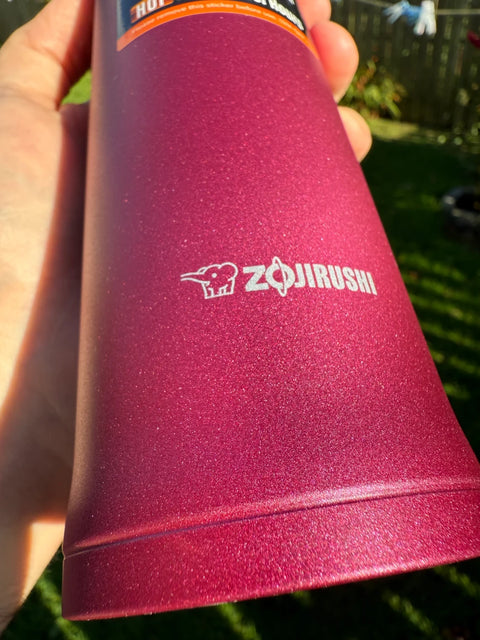 Close-up of Zojirushi SM-QAF60 Carry Tumbler in Red, showing logo and metallic finish, BPA-free stainless steel insulated travel mug
