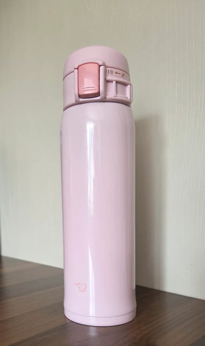Zojirushi SM-SR60 Pink travel mug on a wooden table with light wall background, 360 ml (12.20 oz) to 480 ml (16.20 oz)