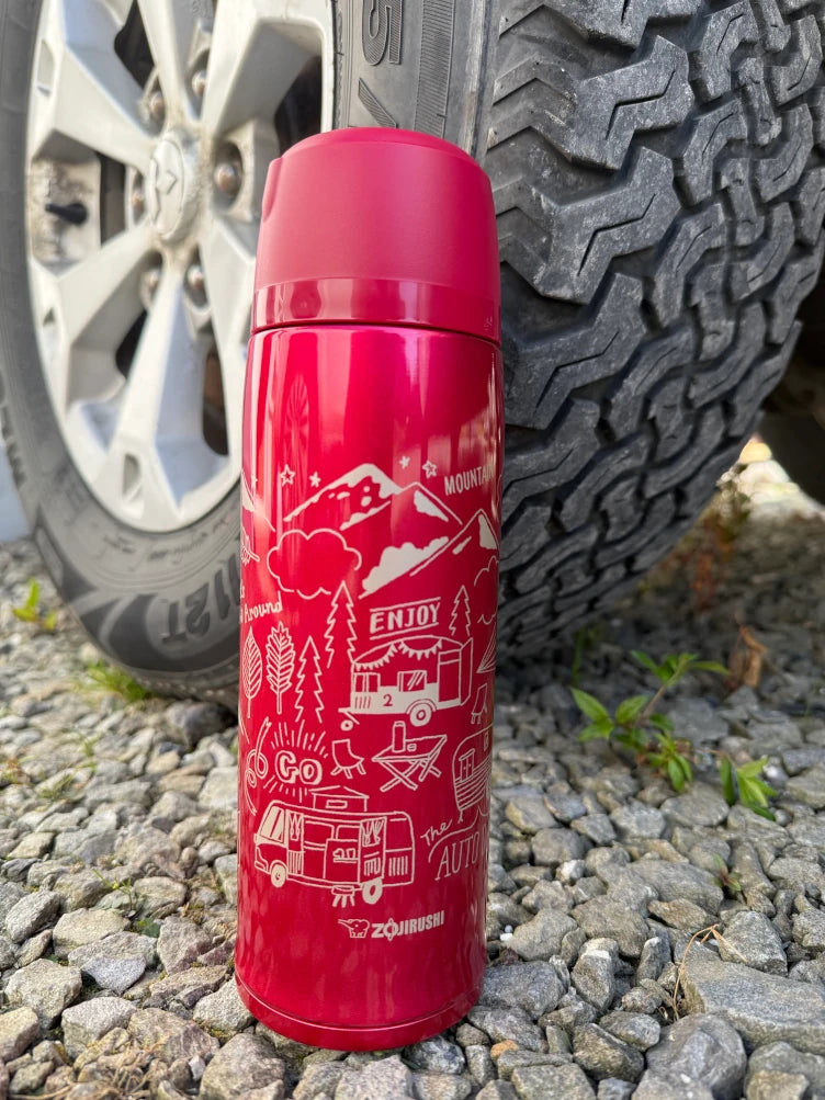 Zojirushi SJ-JS Red Travel Mug with camping design, 800 ml to 1030 ml, on gravel beside a car wheel.near Dublin